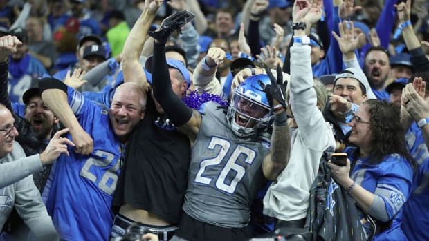Jahmyr Gibbs celebrates amid Lions fans after scoring a touchdown